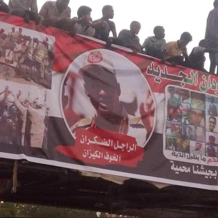 متظاهرون يعلقون بوستر به صورة قائد مليشيات الدعم السريع محمد حمدان (حميدتي) أمام القيادة العامة للجيش السوداني . صورة من (مواقع التواصل الاجتماعي )