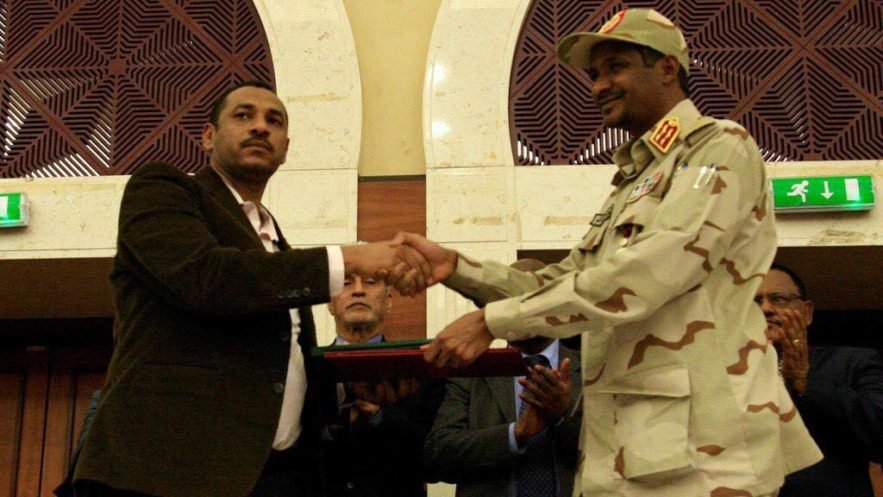 نائب رئيس المجلس العسكري محمد حمدان (حميدتي) نائب رئيس المجلس العسكري وأحمد ربيع، عضو تجمع المهنيين يوقعان اتفاق تقاسم السلطة في السودان . 17 يوليو 2019