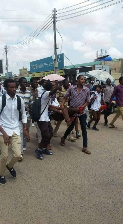 طلاب متظاهرون يحملون أحد مصابي المجزرة