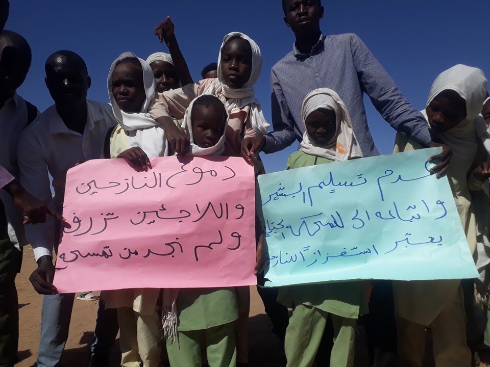 نازحون يرفعون لافتات أثناء زيارة حمدوك لمعسكر ابوشوك تطالب بتسليم مرتكبي الانتهاكات للجنائية